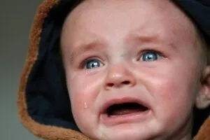 Emotional close-up of a baby in tears, highlighting raw emotion and vulnerability.