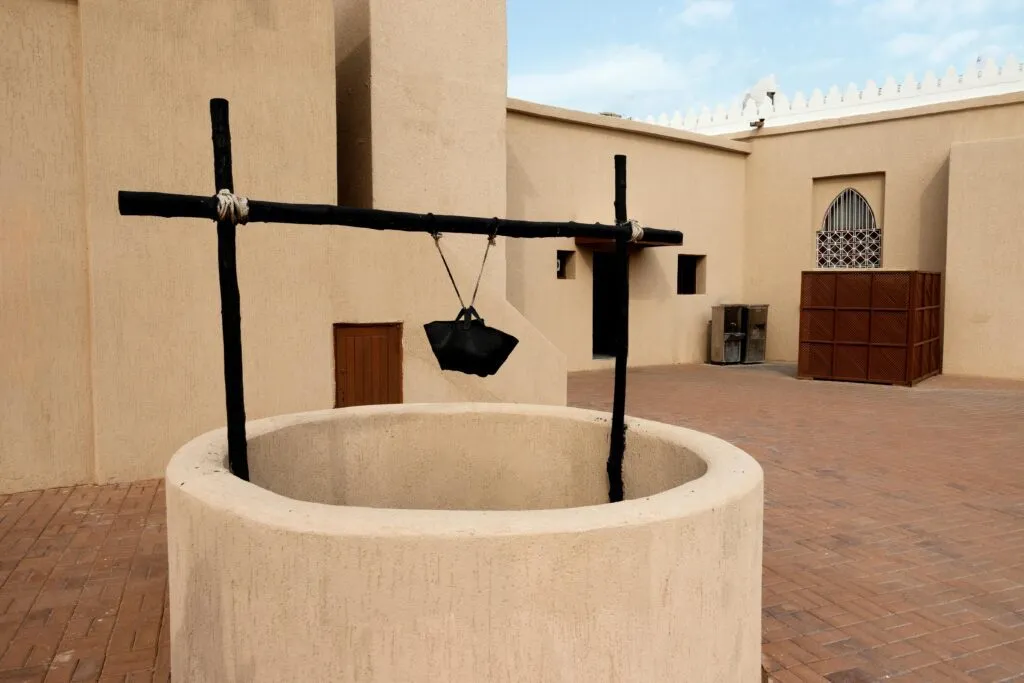A traditional desert house showcasing an ancient well in an outdoor courtyard.