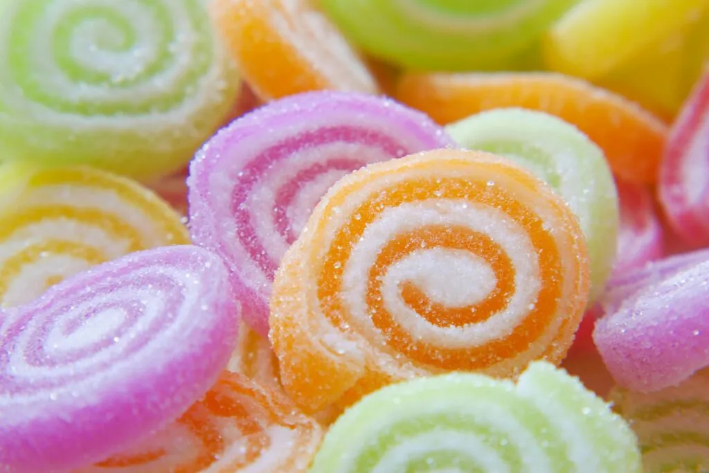 Close-up of colorful sugary swirled gummy candies in various bright hues.
