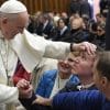 Francesco accarezza un malato durante un'udienza generale in Aula Paolo VI (Vatican Media)
