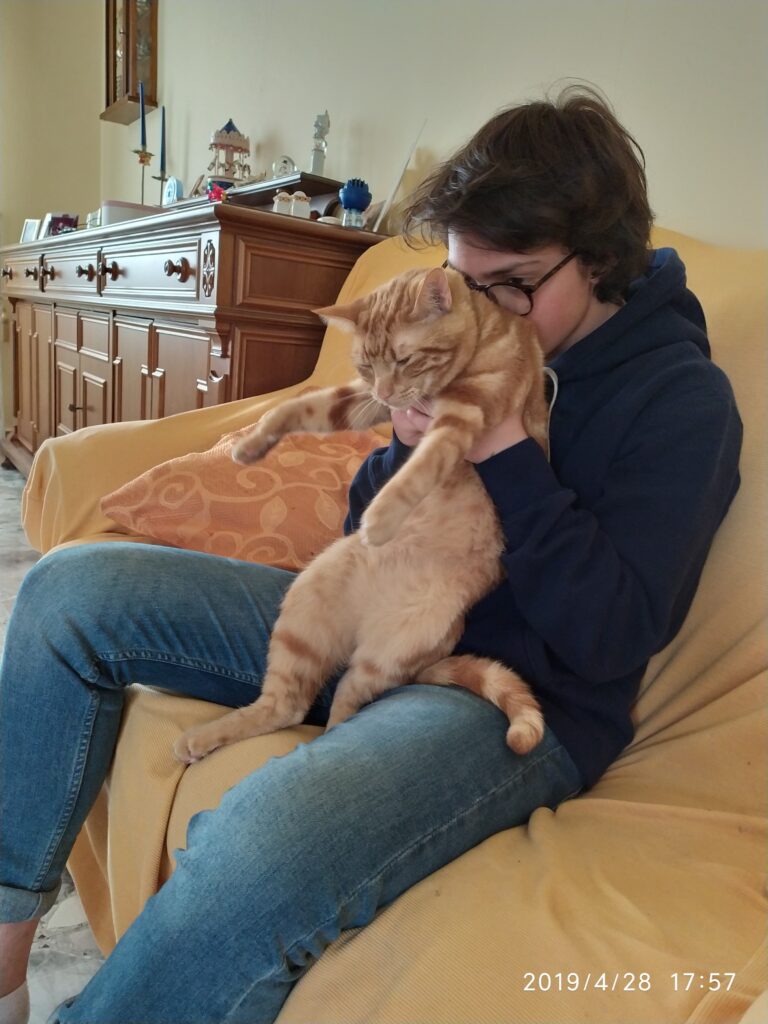 Eugene sostiene al gato Luke en sus brazos.