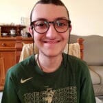 Eugenio sorride con la sua maglietta verde