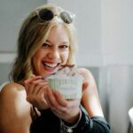 woman in black top holding disposable cup